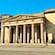 A neoclassical building with stone columns and engravings of a chariot battle scene
